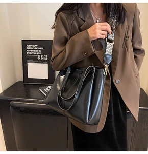 Détail du sac cabas en cuir noir avec bandoulière géométrique tissée et grande capacité