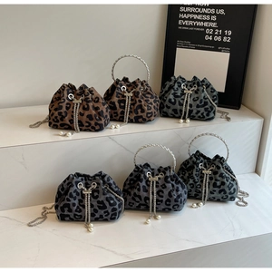 Detail showing cow print bucket bags with metal handles and pearl drawstring pendants