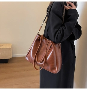 Détail du sac cabas marron avec une large bandoulière à motifs géométriques noir et blanc