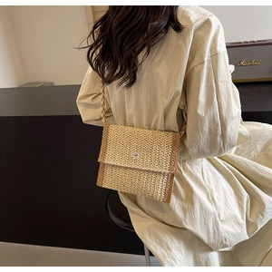 Dettaglio borsa a tracolla in paglia intrecciata a mano beige con chiusura magnetica