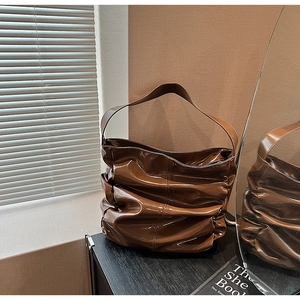 Dettaglio della borsa hobo in pelle verniciata marrone scuro con design increspato