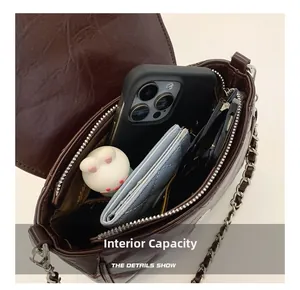 Internal capacity of brown vintage quilted leather bag showing phone and sunglasses