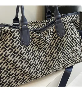 Close-up of black and white geometric jacquard fabric with blue leather handles on tote bag