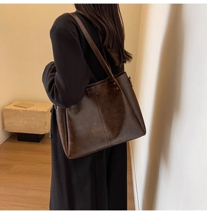Gros plan du sac cabas en cuir ciré marron foncé avec rivets métalliques