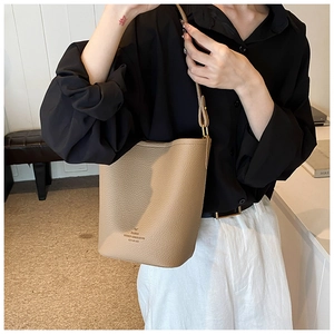 Detailed macro view of litchi-grain khaki bucket bag with Paris Modern text