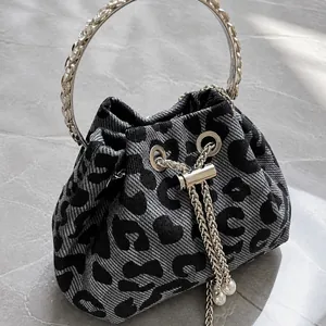 Detail of leopard print bucket bag with metal ring handle and pearl drawstring closure
