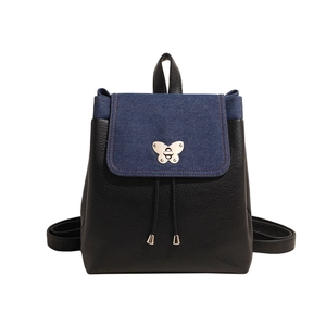Women's backpack featuring denim patchwork design and butterfly metal lock on white background