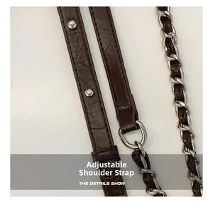 Close-up of the adjustable shoulder strap with silver hardware on a dark brown bag