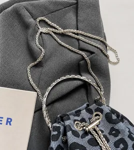 Detail of animal print bucket bag with silver chain strap and circular metal handle