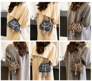 Detailed views of cow print bucket bag featuring metal chain and pearl charm detail