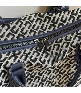 Close-up of smooth dual metal zippers and jacquard fabric on travel tote bag
