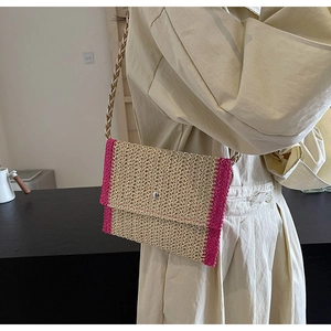 Dettaglio borsa a tracolla in paglia intrecciata con bordo rosa all'uncinetto e fibbia