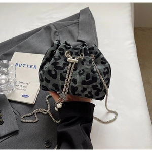 Detailed view of grey leopard print bucket bag with metal chain and pearl pendant charm