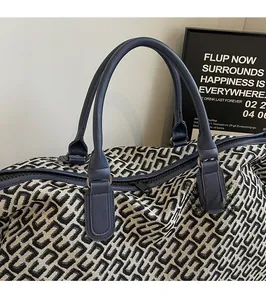 Close-up of horseshoe print travel tote with leather handles and reinforced zipper detail