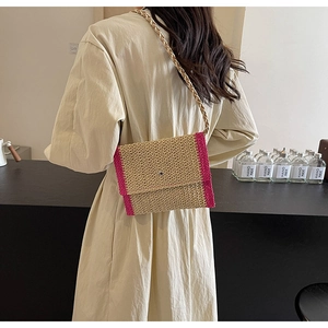 Dettaglio della borsa a tracolla in paglia intrecciata con bordi rosa e tracolla a spirale
