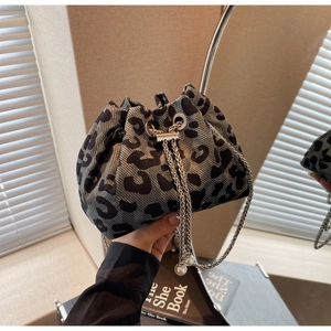 Detail of leopard print bucket bag with silver chain strap and pearl drawstring accents