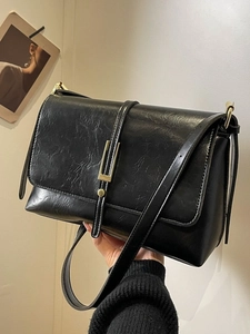 Vintage black leather shoulder bag with elegant gold clasp and textured finish