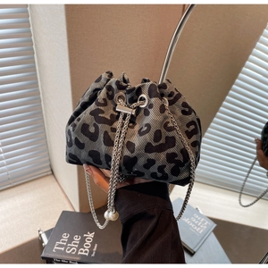 Detail of leopard print bucket bag featuring silver chain strap and large pearl accent