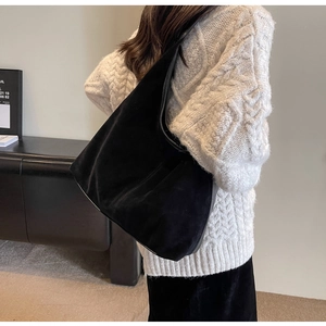 Detail of a large black suede tote bag showing soft texture and spacious hobo design