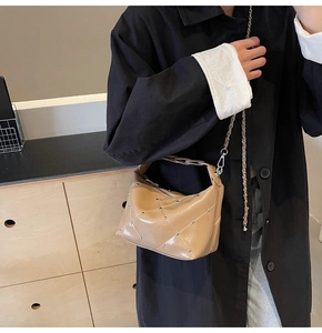 Detail of light coffee shoulder bag with quilted diamond pattern and silver mini rivets