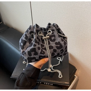 Detail of grey leopard print bucket bag with silver chain and pearl ornament ball