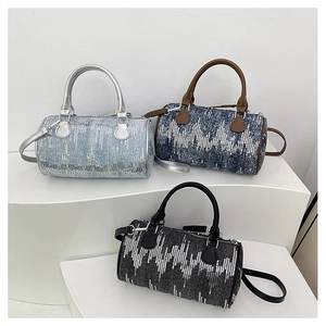 Detailed view of denim cylinder bags in three colors with wavy silver sequin patterns