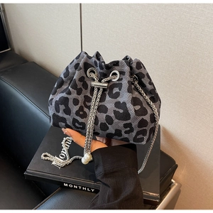 Close-up of leopard pattern bucket bag with silver chain and pearl drawstring charms