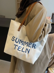 Grand sac cabas en toile beige avec broderie bleue et anses en cuir marron élégant