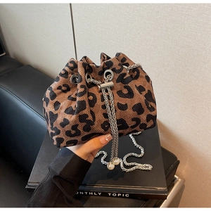 Close-up of leopard print bucket bag with metal chain strap and pearl charms