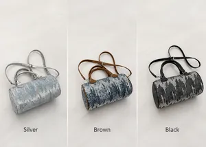 Three color options of denim cylinder bags featuring vertical texture and slim straps