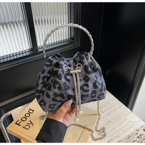 Detail of leopard print bucket bag with metal ring handle and pearl drawstring charms