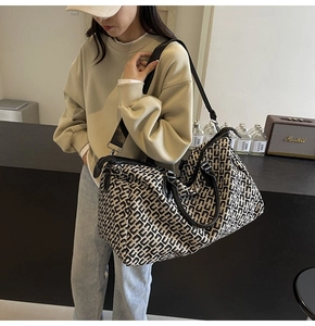 Detailed view of spacious travel tote bag with geometric pattern and leather handles