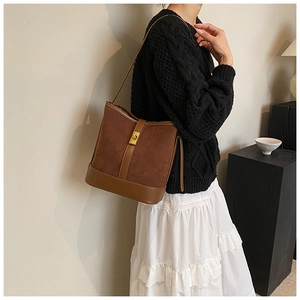Chic brown suede bucket bag shown with elegant knitwear and white lace skirt