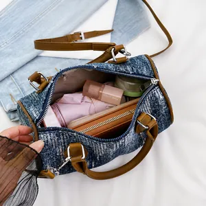 Interior view showing the large capacity of the denim cylinder bag with brown leather handles