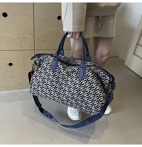 Detail of large travel tote bag with C-pattern fabric and leather handles