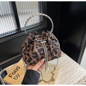 Detail of leopard print bucket bag with diamond-encrusted handle and pearl charms