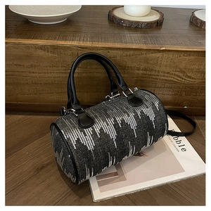 Macro detail of dark denim Boston bag with vertical silver sequin stripes and leather handles