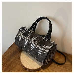 Close-up of vintage denim barrel bag with silver sequins and premium leather handles