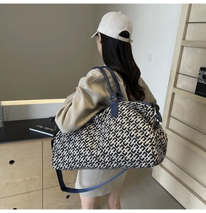 Detail of large travel tote bag with blue geometric pattern worn by a model