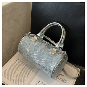 Detail of light blue denim cylinder bag with silver sequins and adjustable strap