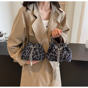 Detail of leopard print bucket bag featuring silver chain strap and pearl accents