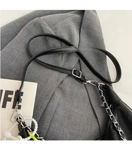 Close-up of black crocodile texture tote bag with silver chain and leather shoulder strap