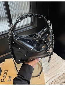 Minimalist black patent leather shoulder bag with quilted texture and silver rivets