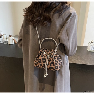 Detail of leopard print bucket bag featuring pearl charms and silver metal ring handle
