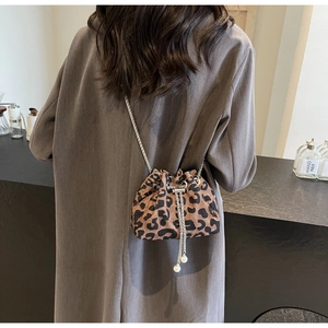 Detail of leopard print bucket bag with silver chain strap and pearl tassel charms