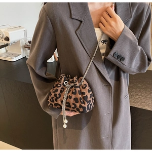Close-up of leopard print bucket bag featuring silver chain and pearl drawstring details