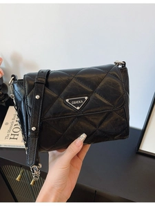 Quilted black crossbody bag with silver triangle logo and metal chain strap detail