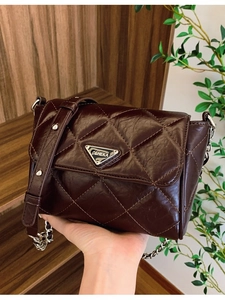 Deep brown quilted chain shoulder bag with metal logo and oil-wax leather texture