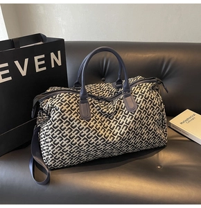 Detailed close-up of large travel tote with geometric patterns on a luxury sofa