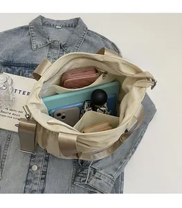 Detail view of large capacity nylon tote interior with compartments on denim background